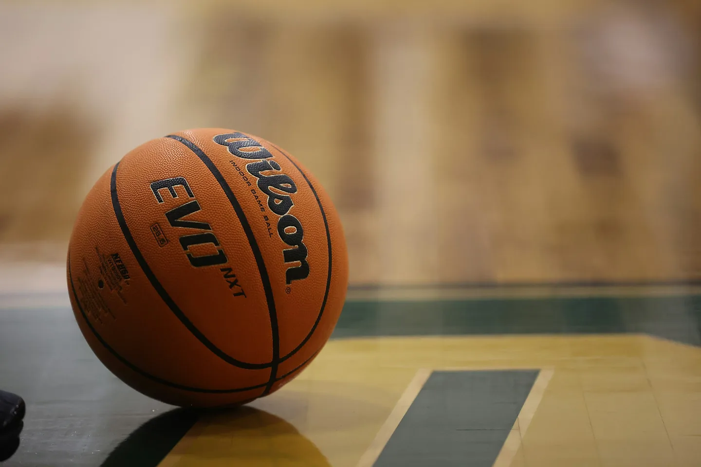 A basketball on the floor of a school gym